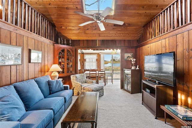 carpeted living room featuring high vaulted ceiling, ceiling fan, wooden ceiling, and wood walls