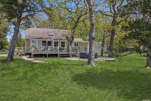 rear view of property with a deck and a yard