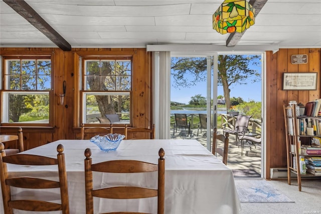 carpeted dining room featuring wooden walls and wooden ceiling