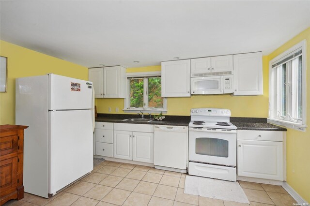 kitchen with sink, white cabinets, white appliances, and light tile patterned floors