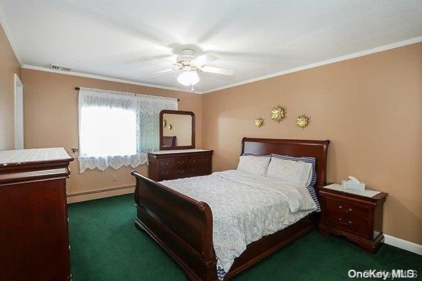 bedroom featuring baseboard heating, ceiling fan, dark carpet, and ornamental molding