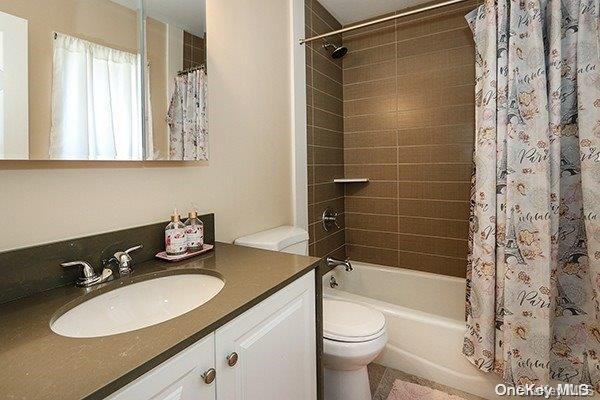 full bathroom with vanity, toilet, and shower / bath combo with shower curtain