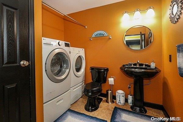 laundry room featuring washing machine and dryer, tile patterned floors, and sink