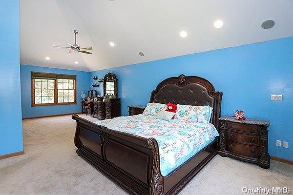 bedroom featuring ceiling fan, light carpet, and vaulted ceiling