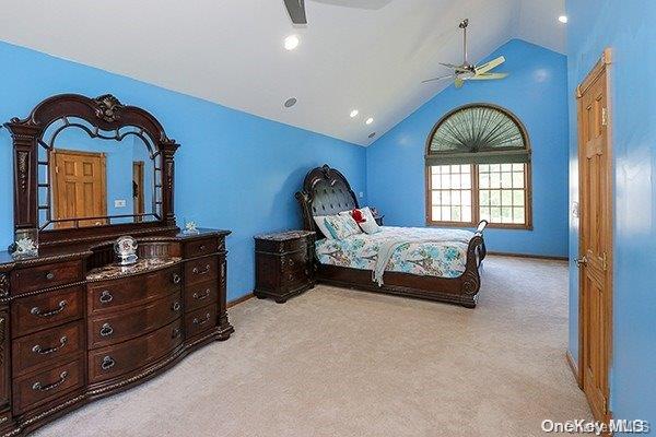 carpeted bedroom featuring ceiling fan and high vaulted ceiling