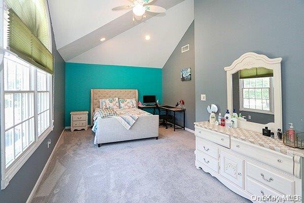 bedroom with light colored carpet, high vaulted ceiling, and ceiling fan