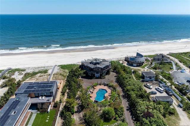 birds eye view of property featuring a water view and a beach view