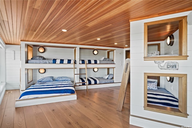 bedroom with hardwood / wood-style floors, wooden ceiling, and wood walls