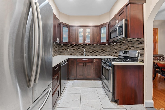 kitchen featuring light hardwood / wood-style floors, sink, stainless steel appliances, and tasteful backsplash