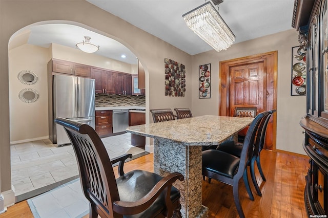 dining area featuring light hardwood / wood-style flooring and a chandelier