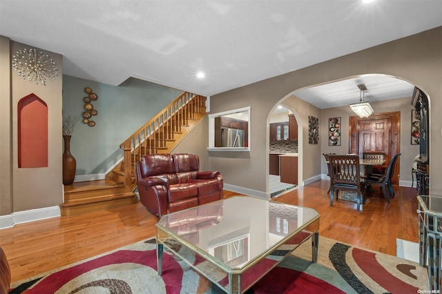 living room featuring wood-type flooring and a textured ceiling