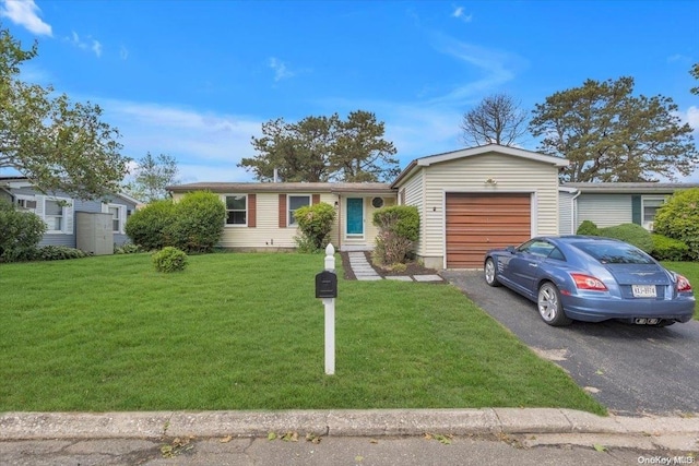 ranch-style house featuring a garage and a front lawn