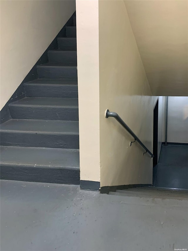 staircase featuring concrete flooring