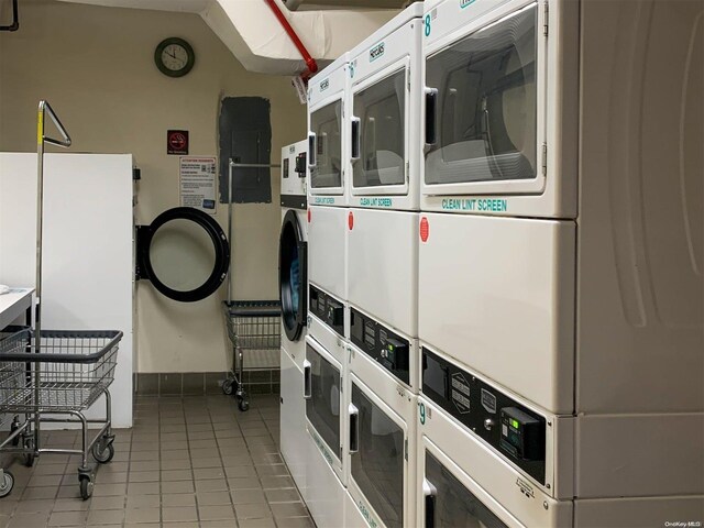 interior space with stacked washer / drying machine and light tile patterned floors