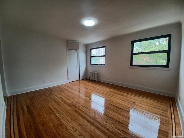 unfurnished room with light wood-type flooring and radiator heating unit