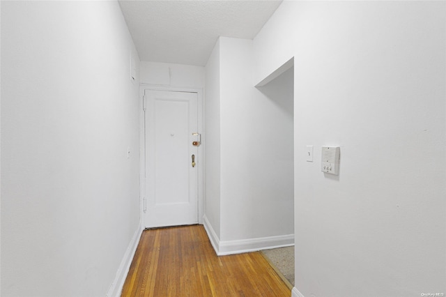 hall featuring wood-type flooring and a textured ceiling