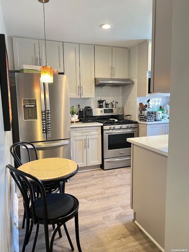 kitchen with backsplash, light hardwood / wood-style floors, and appliances with stainless steel finishes