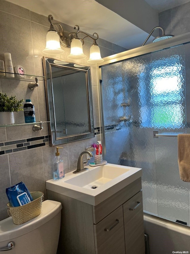 full bathroom with enclosed tub / shower combo, backsplash, toilet, vanity, and tile walls