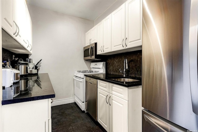 kitchen with white cabinets, dark tile patterned flooring, sink, decorative backsplash, and stainless steel appliances