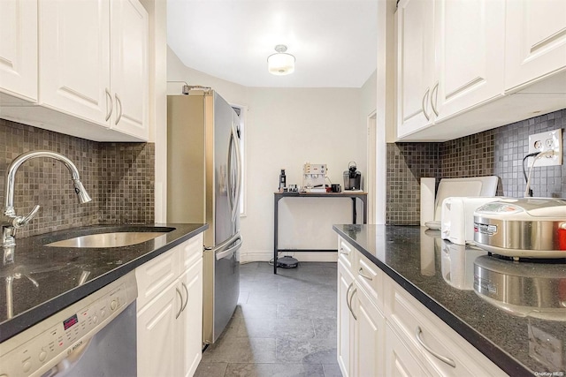 kitchen featuring backsplash, stainless steel appliances, white cabinetry, and dark stone counters