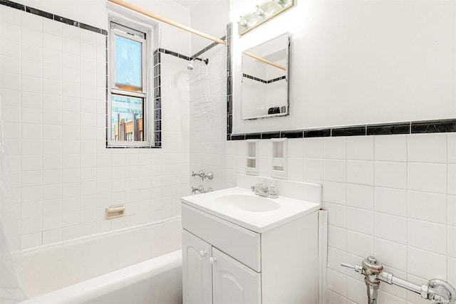 bathroom with vanity, tile walls, and tiled shower / bath combo