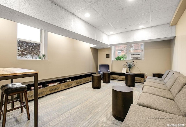 living room featuring carpet floors and a drop ceiling