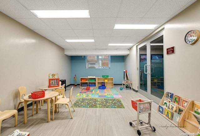 recreation room with hardwood / wood-style flooring and a drop ceiling