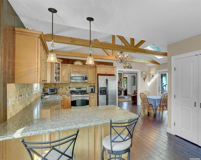 kitchen featuring kitchen peninsula, appliances with stainless steel finishes, tasteful backsplash, dark hardwood / wood-style floors, and hanging light fixtures