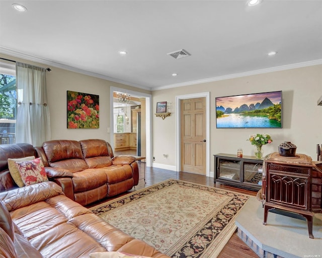 living room with hardwood / wood-style flooring, a notable chandelier, and crown molding