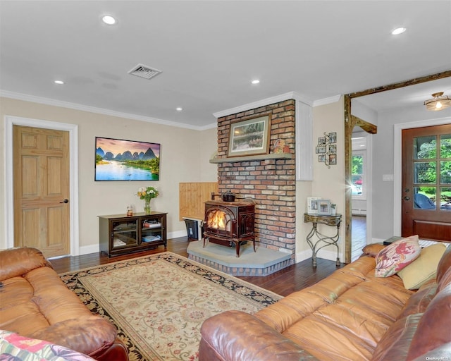 living room featuring hardwood / wood-style flooring, a wood stove, and ornamental molding