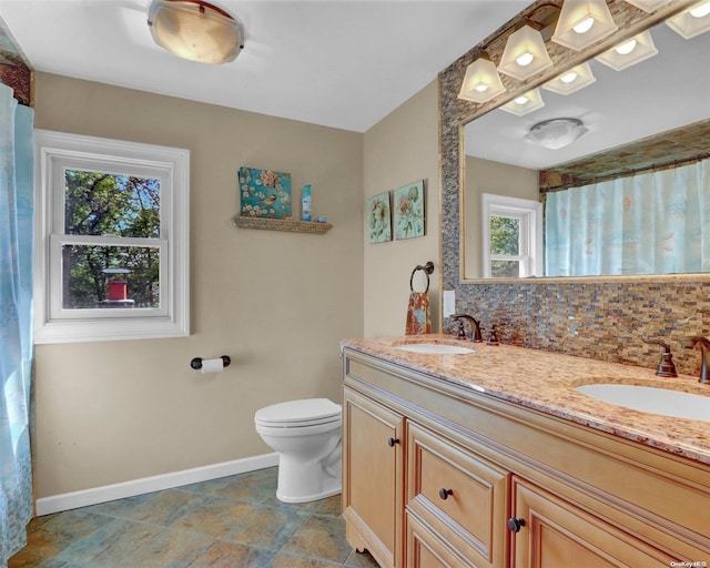 bathroom featuring backsplash, vanity, and toilet