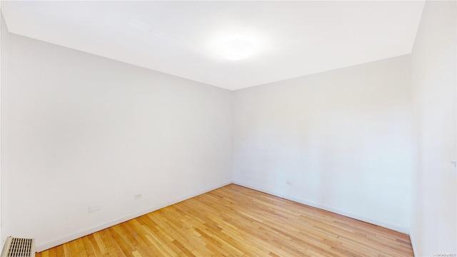 empty room with radiator and light wood-type flooring