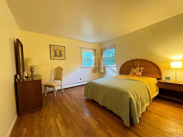 bedroom featuring baseboard heating and hardwood / wood-style floors