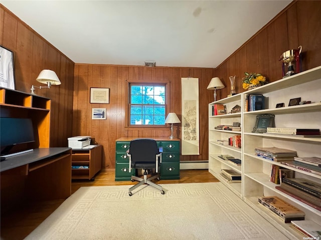 office featuring a baseboard radiator, wooden walls, and light hardwood / wood-style flooring