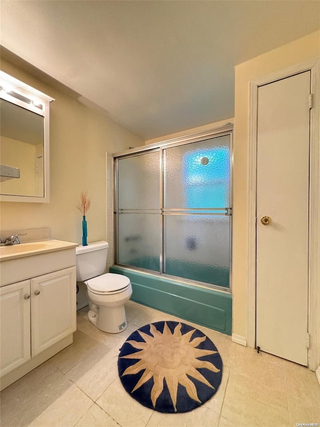 full bathroom with shower / bath combination with glass door, vanity, tile patterned floors, and toilet