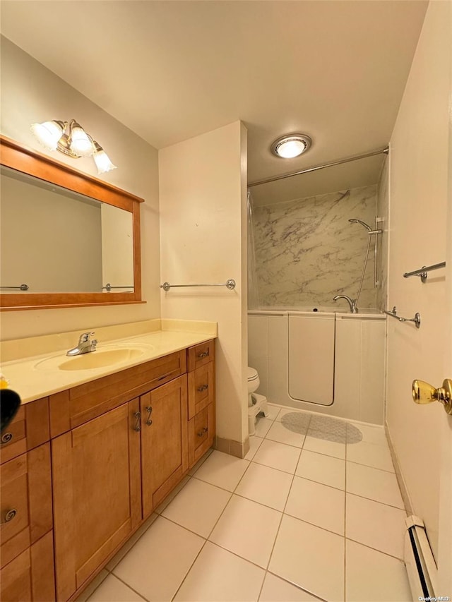 bathroom with a tile shower, tile patterned flooring, a baseboard heating unit, toilet, and vanity