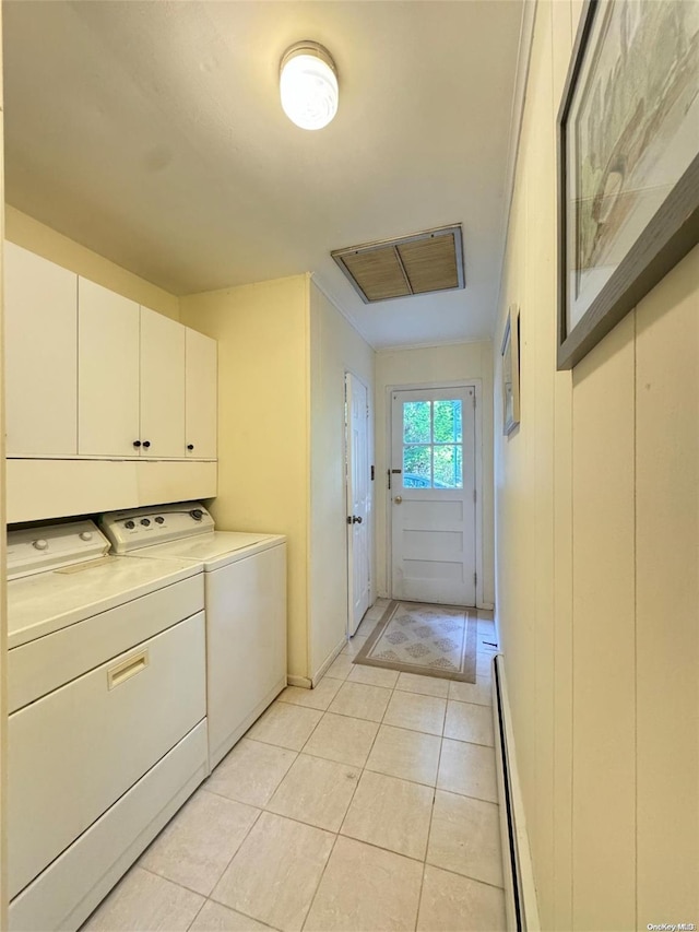 clothes washing area with washer and clothes dryer, light tile patterned flooring, cabinets, and a baseboard radiator