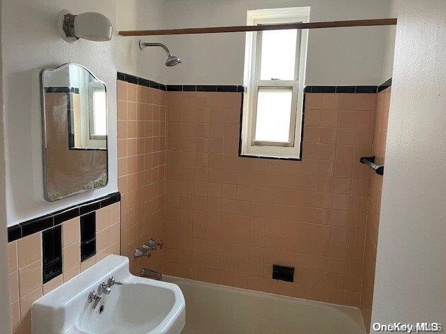 bathroom featuring sink and tiled shower / bath