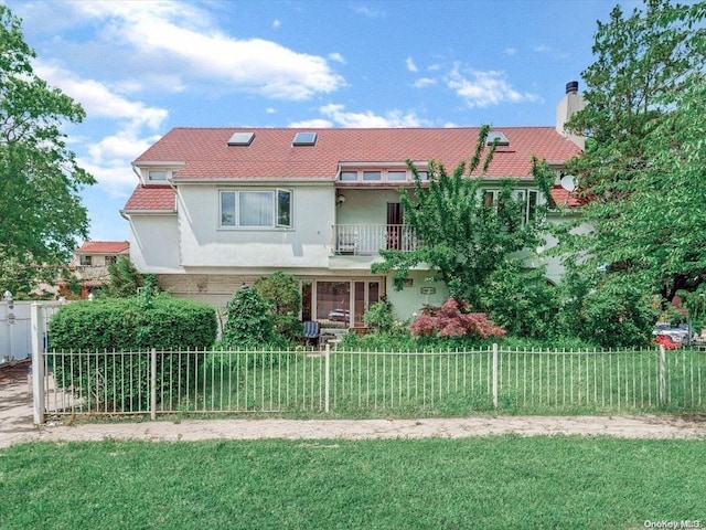 view of front of home featuring a balcony and a front lawn