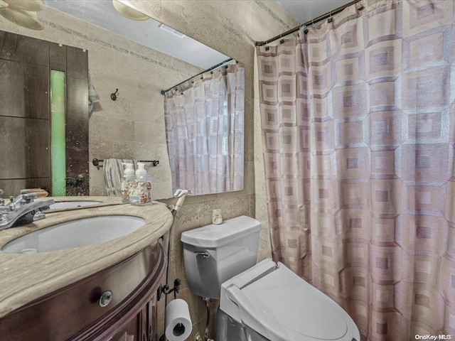 bathroom with a shower with curtain, vanity, tile walls, and toilet