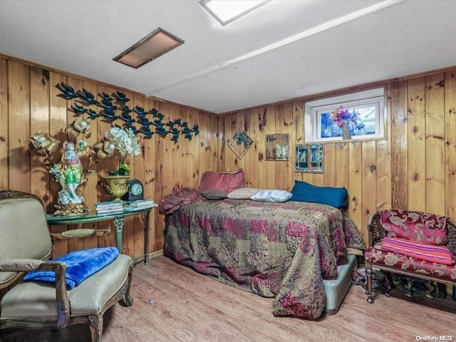 bedroom featuring wood walls and light hardwood / wood-style floors