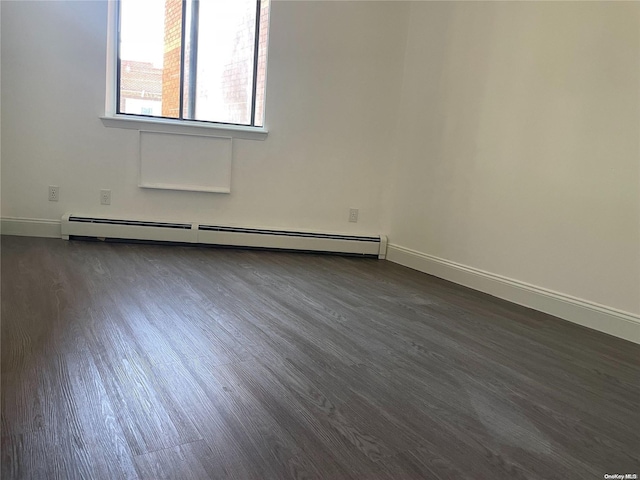 empty room featuring dark hardwood / wood-style flooring and baseboard heating