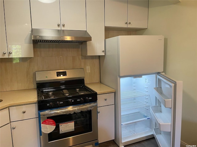 kitchen with white cabinets, backsplash, white fridge, and stainless steel range oven