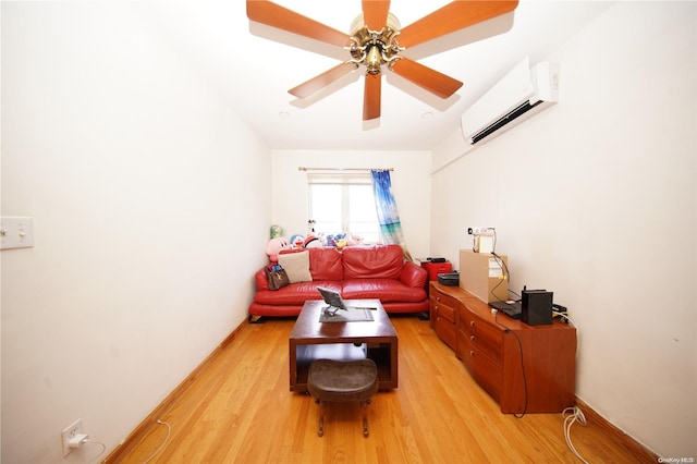 living room with a wall mounted air conditioner, ceiling fan, and light hardwood / wood-style floors