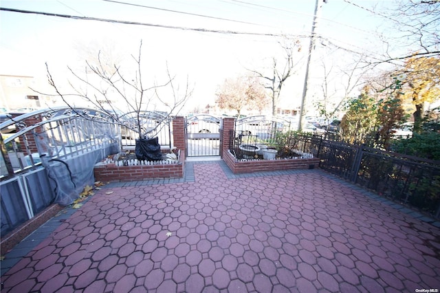 view of gate featuring a patio area