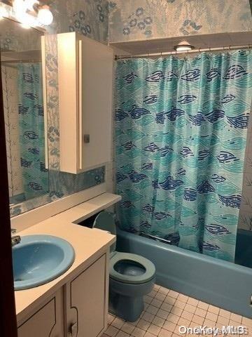 bathroom featuring tile patterned floors, vanity, and shower / tub combo