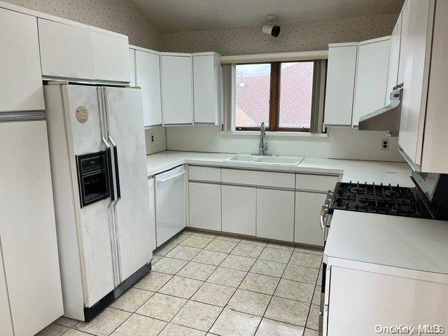 kitchen with white cabinetry, white appliances, sink, and vaulted ceiling