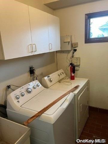 washroom with washing machine and dryer and cabinets