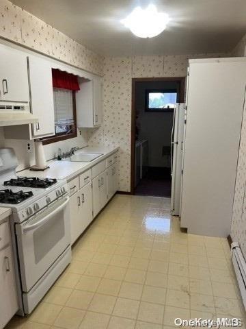 kitchen featuring white appliances, a baseboard heating unit, white cabinets, sink, and extractor fan