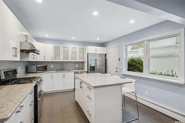 kitchen with appliances with stainless steel finishes, white cabinets, and a center island